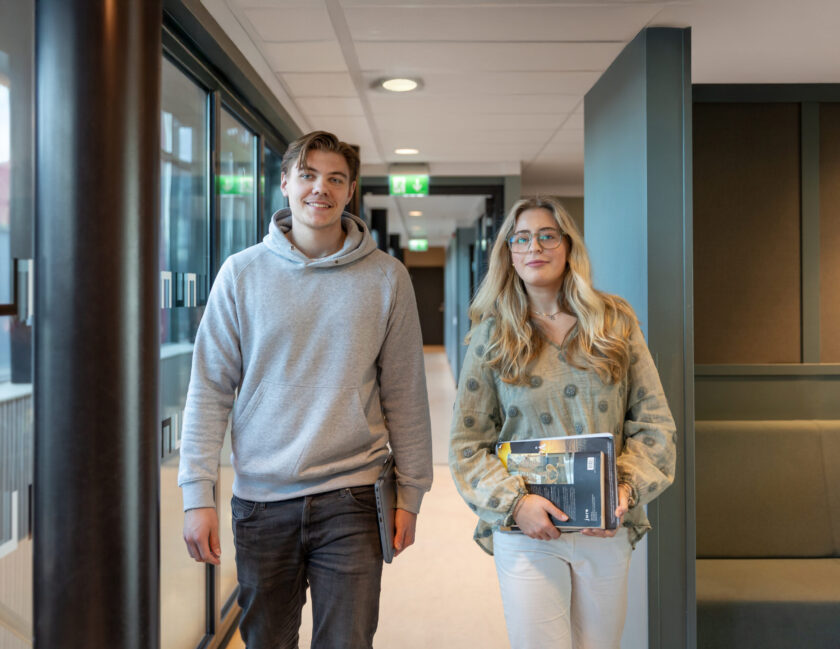 Två elever i en korridor